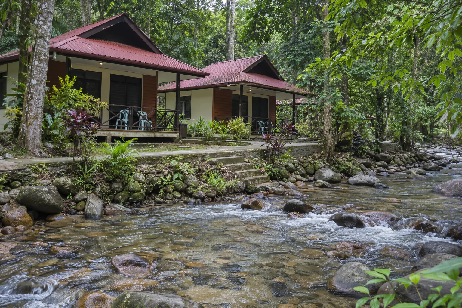 Illustrative riverside chalets with simple outdoor seating